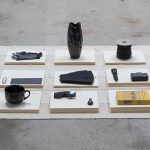 Amanda Ross-Ho and Diedrick Brackens. <em>Untitled Floor Arrangement (DRAMA)</em>, 2017. Handwoven cotton rugs, manilla folders, sensitive documents, labels, lint roller, black nitrile gloves, black vase, double fold bias tape (roll), ice scraper, plastic salsa bowl, oversized black paper clip, vinyl letters, material test with oversized black paper clip, material test with binder clip, camera case, three black owl glasses origin unknown, staple remover, satin seam binding, yarn ball, black mug, sunglasses, measuring spoon, DRAMA book, black scrunchie, and material test with oversized gold paper clip, 11 1/2 x 81 x 44 inches