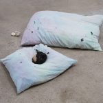 Lila de Magalhaes and Roni Shneior. <em>Close the Door Behind You</em>, 2017. Clay, resin, acrylic, dyed fabric, silver thread, hay, wig, and cigarettes, 16 x 80 x 72 inches