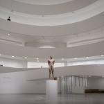 <em>Monumento II</em>, Still from documentation video of performance, Guggenheim, 2021. “I remain standing and handcuffed on a pedestal in the center of the museum’s rotunda.”